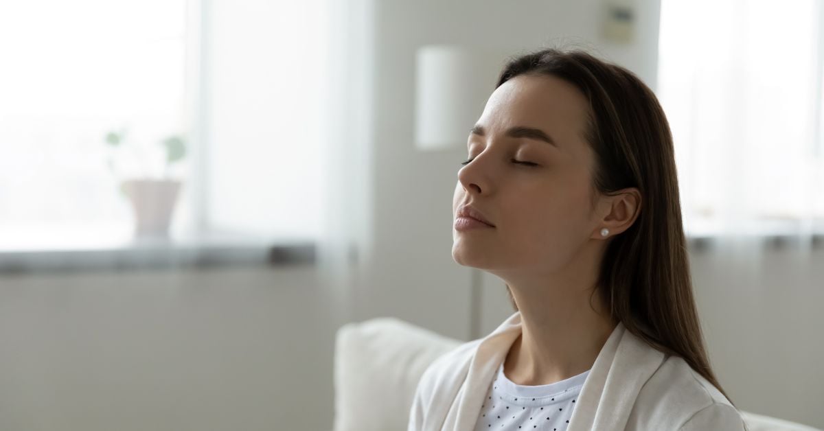 Blog background depicting woman deep breathing with title "How Mindfulness and Meditation Improve Mental Health"